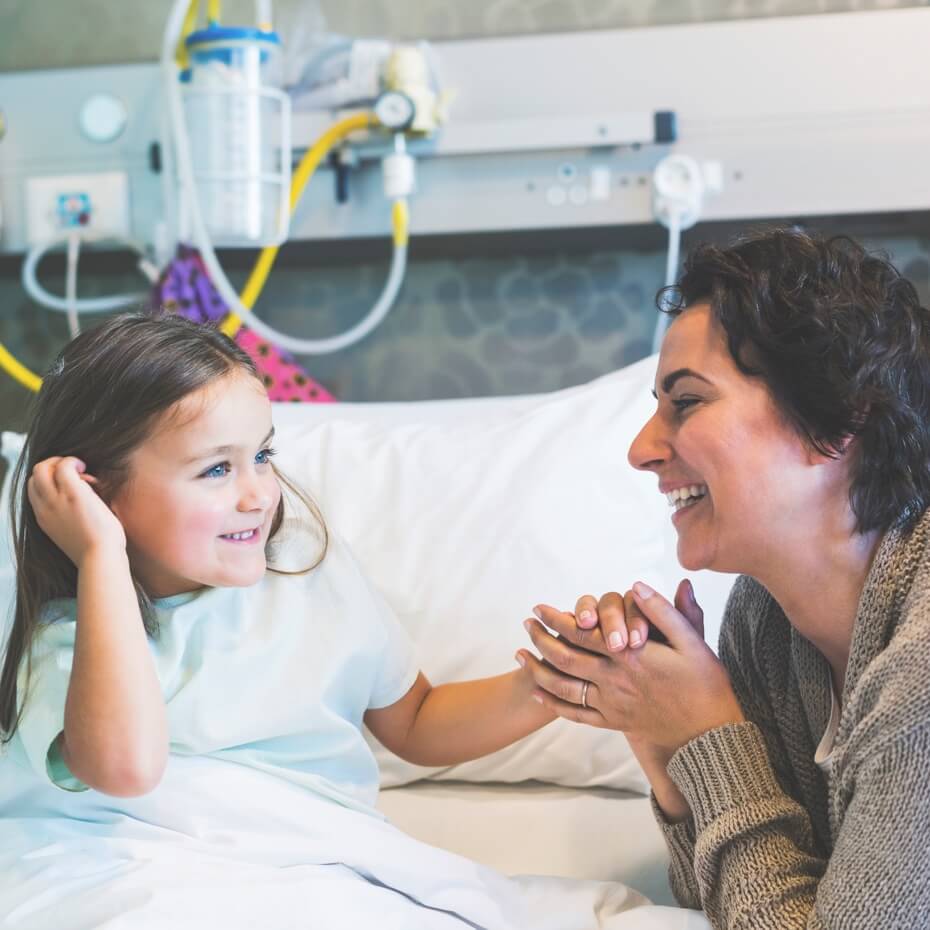 Little girl on a hospital bed with her mom